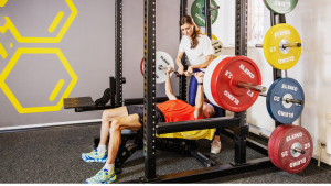 Julia Striffler beim Personaltraining mit einem Kunden an der Langhantel im Fitlab Stuttgart.