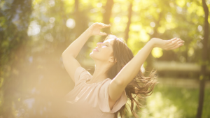 Die strahlende Sonne am Himmel durch Baumwipfel hindurch.