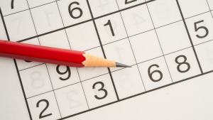 Klassisches Sudoku-Rätselraster, halb ausgefüllt mit Bleistiftmarkierungen, Symbol für Gehirntraining und Logikaufgaben.