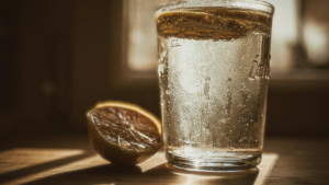 Ein Glas Wasser mit frischen Zitronenscheiben als Symbol für ausreichende Hydration und Vitaminzufuhr während einer Sportpause.