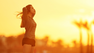 Frau mit Kopfhörern genießt Morgensport bei Sonnenaufgang – Frühaufsteher Morgenroutine Fitlab Stuttgart
