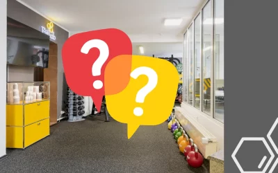 Trainingsfläche des Fitlab Stuttgart mit zwei Fragezeichen-Sprechblasen zur Frage nach den Preisen